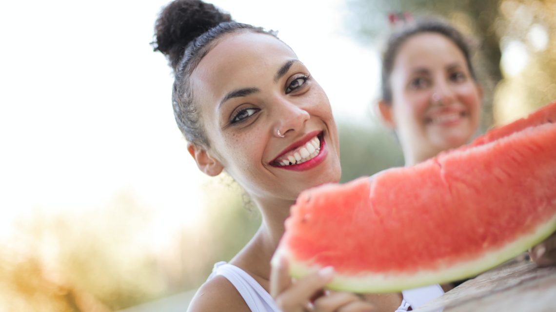 Smiling woman eating watermelon