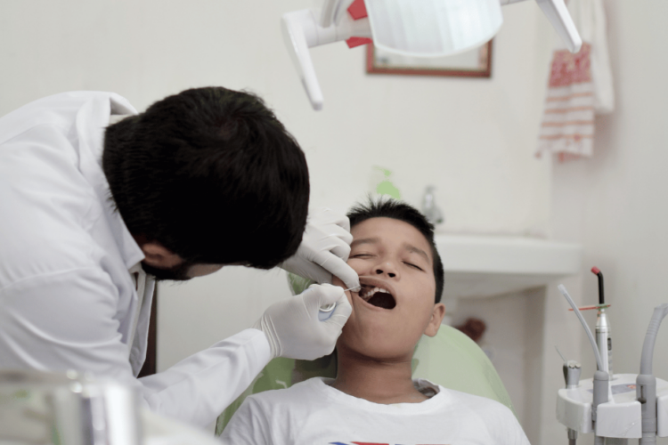 Dentist checking child for cavities