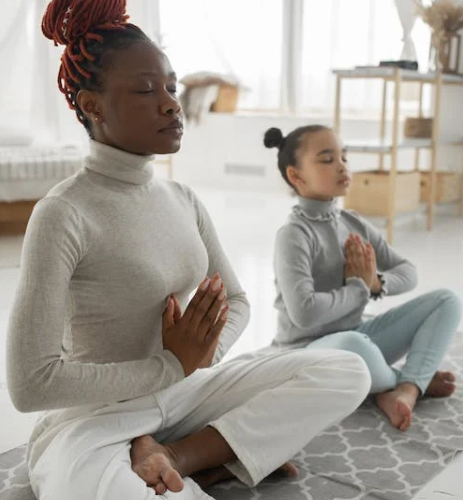 Mother and daughter staying calm doing yoga