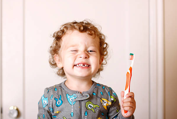 Toddler brushing teeth happy