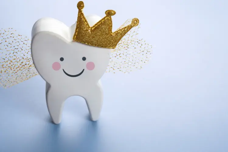 Photo of a molar with a tiara and wings against a blue background