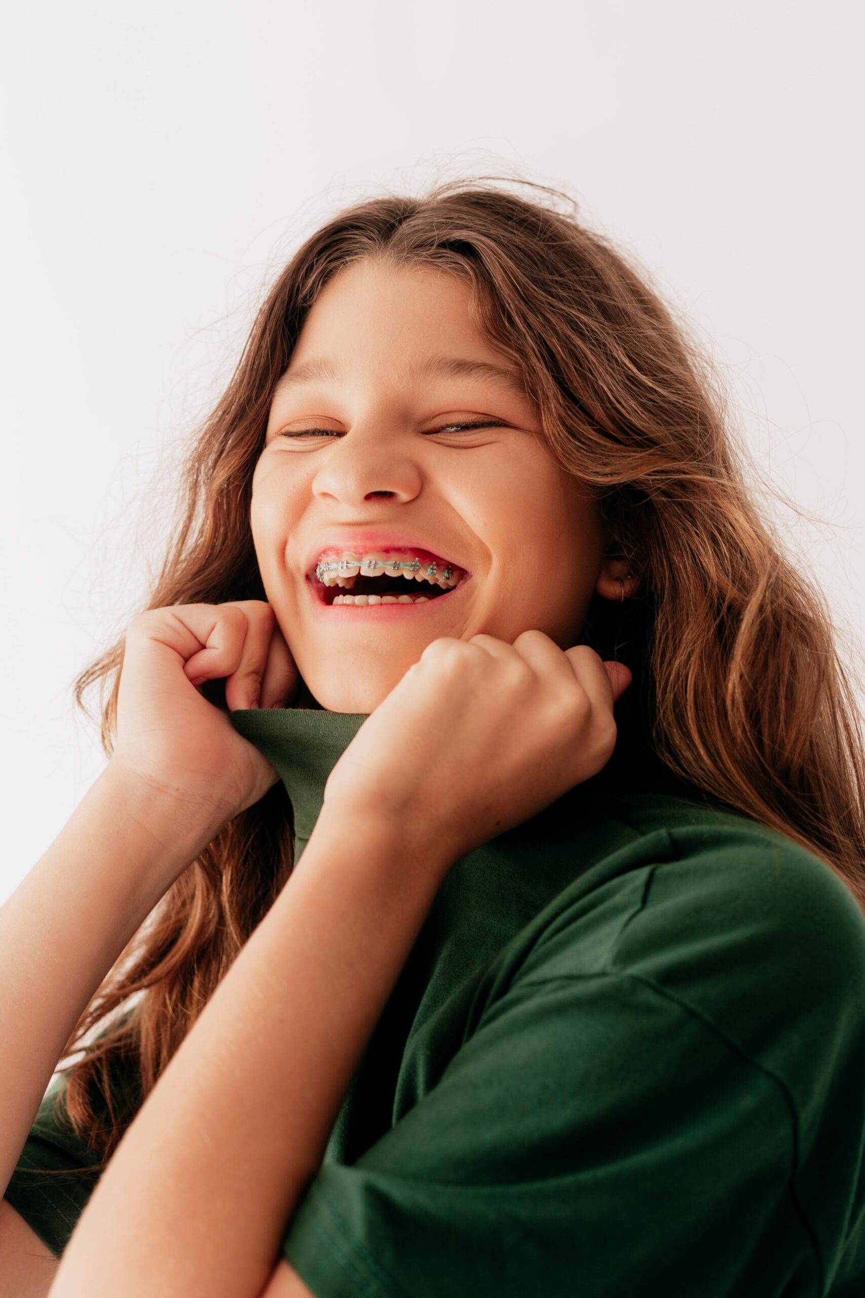 Smiling Girl with braces wearing green shirt