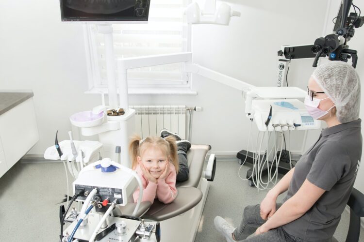 Smiling child sitting in dental chair with dentist