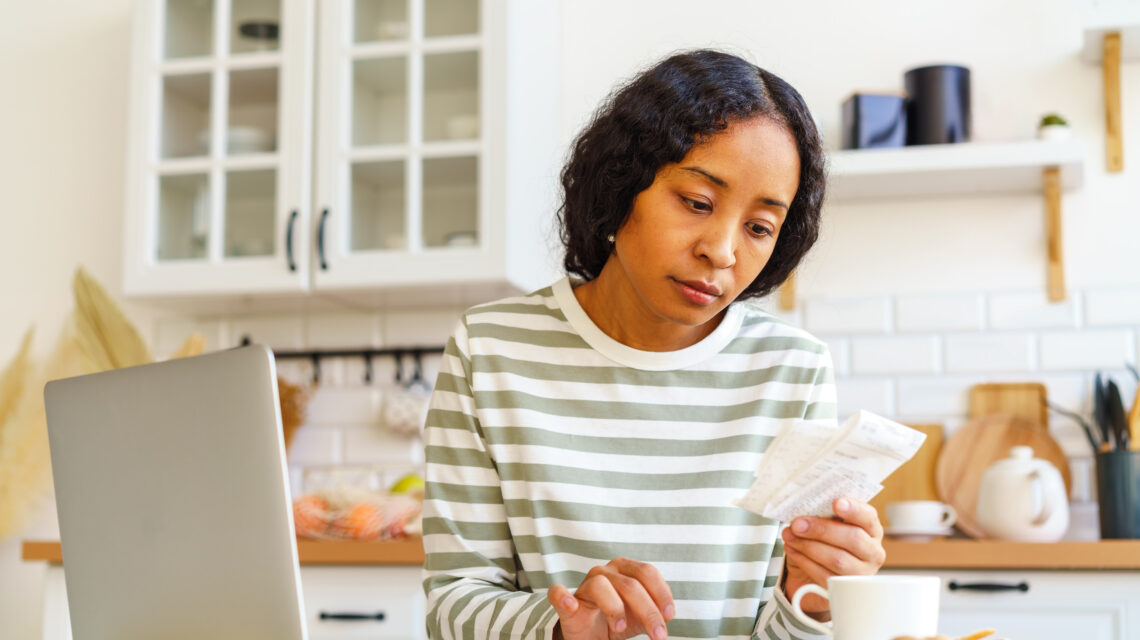 Africanamerican female paying bills dealing with accountancy on smartphone remote bookkeeping