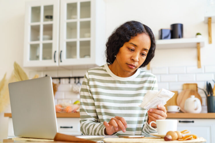 Africanamerican female paying bills dealing with accountancy on smartphone remote bookkeeping